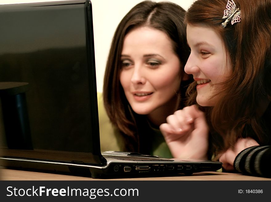 2 girls laughing happy looking to a laptop. 2 girls laughing happy looking to a laptop