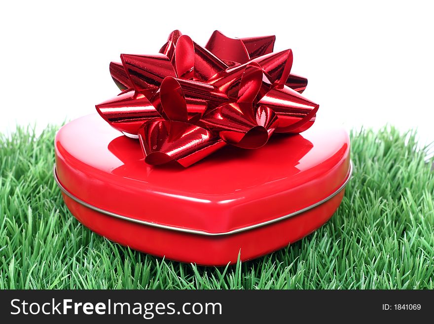 Close up of heart shaped gift box with chocolates on a green grass. Close up of heart shaped gift box with chocolates on a green grass