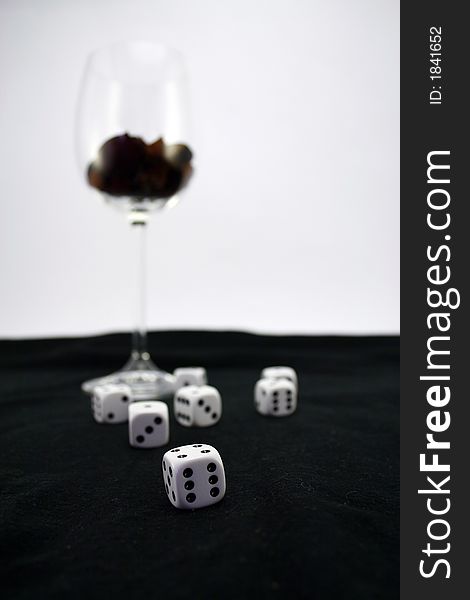 Wine glass on black background with dice. Wine glass on black background with dice