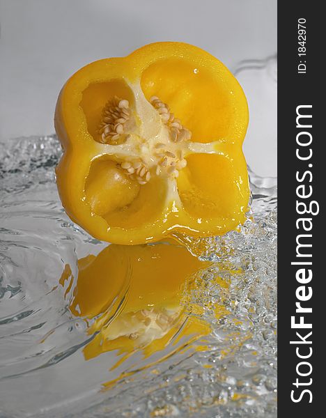 Yellow paprika over mirror in water splashes. Yellow paprika over mirror in water splashes