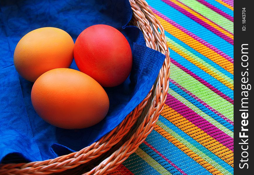 Three eggs in the basket on striped fabric. Three eggs in the basket on striped fabric