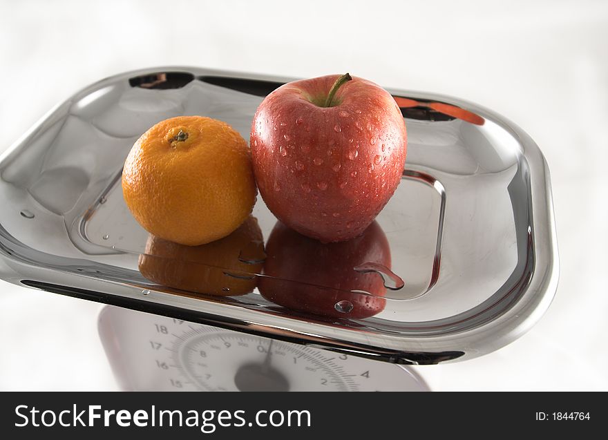 These a Apple & Orange on a Kitchen Scale, Clean Background