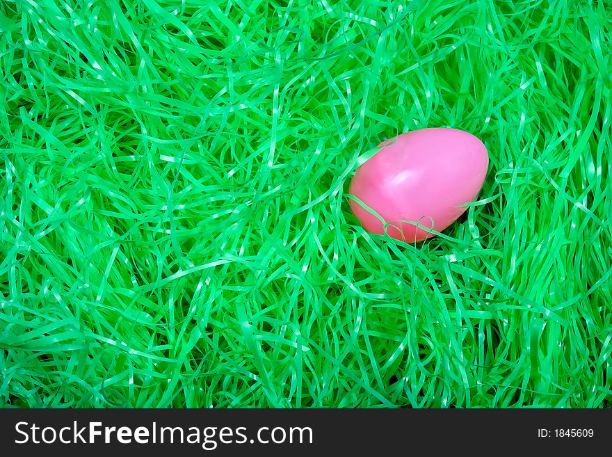 Pink Easter egg on bed of easter grass. Pink Easter egg on bed of easter grass