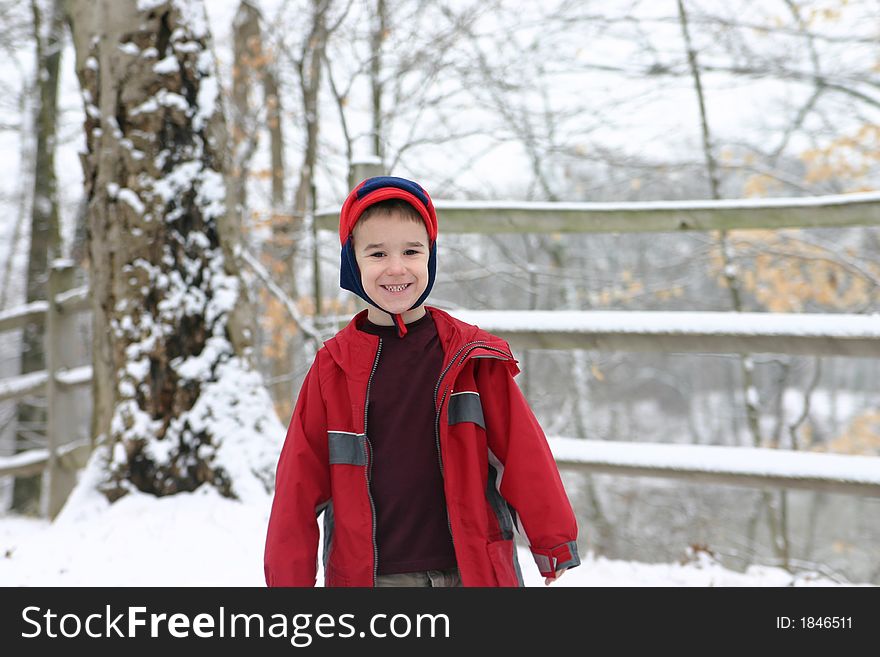 A Winter Scene with a Young Boy Smiling. A Winter Scene with a Young Boy Smiling