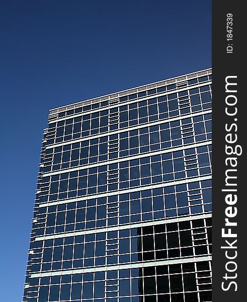 Blue Glass building with reflection and blue sky