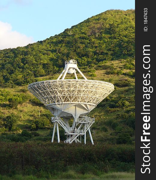 Radio telescope satellite dish against a hillside