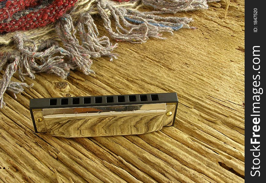 Harmonica on weathered wood with Western-style blanket