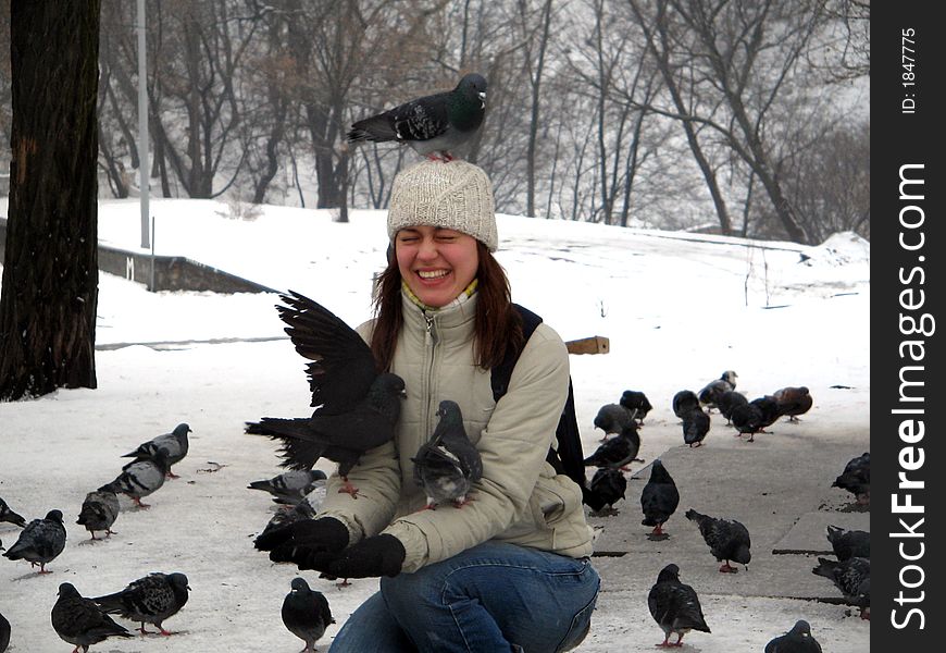 Many pigeons are sitting on a young girl. Many pigeons are sitting on a young girl