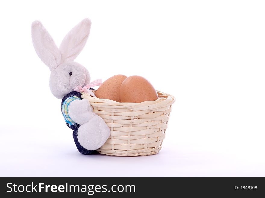 Stuffed bunny with basket full of eggs over white background