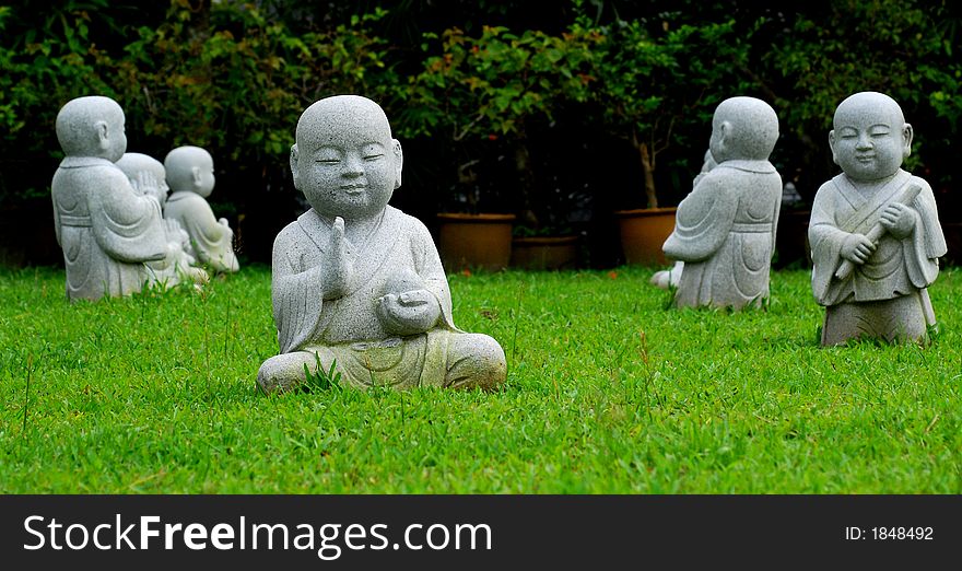 Little monk statues scatter on a field