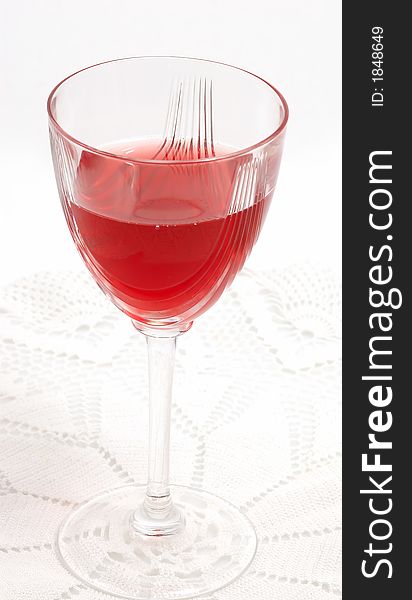 Red glass of wine on vintage lace