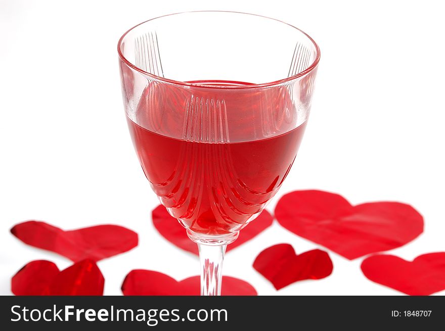 Red glass of wine with red hearts in background