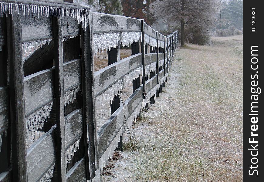 Wooden fence covered with icecicles on a frosty morning. Wooden fence covered with icecicles on a frosty morning.