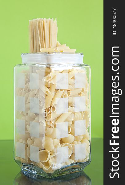 Shaped pasta with spaghetti has a green background