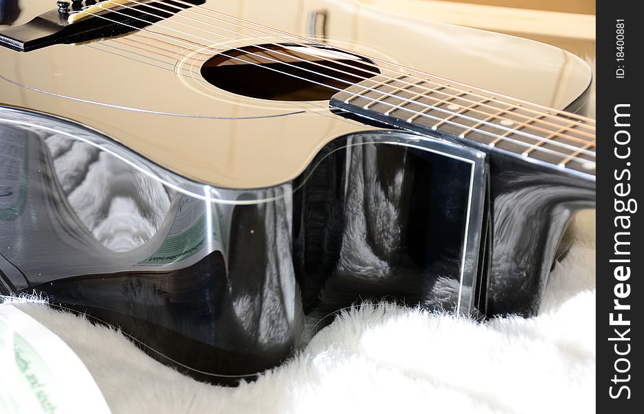 Black acoustic guitar with various light reflections