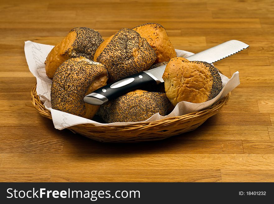 Fresh Bread Rolls and knife In Basket on wooden table. Fresh Bread Rolls and knife In Basket on wooden table