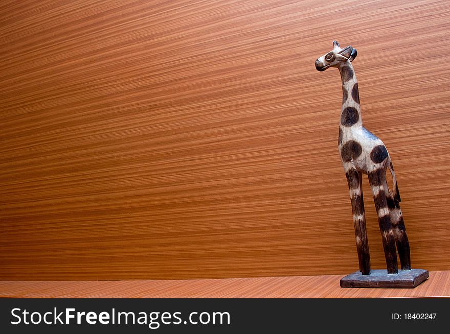 A giraffe handicraft with a wooden background. A giraffe handicraft with a wooden background