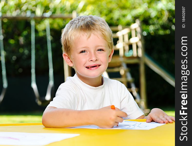 Cute boy poses and smiles outdoor while at preschool. Cute boy poses and smiles outdoor while at preschool