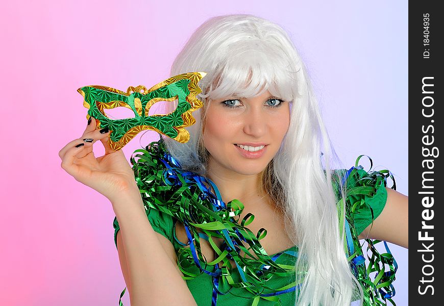 Beautiful party woman in carnival mask and wig celebrating