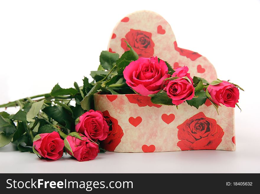 Fresh roses with heart gift box on white background