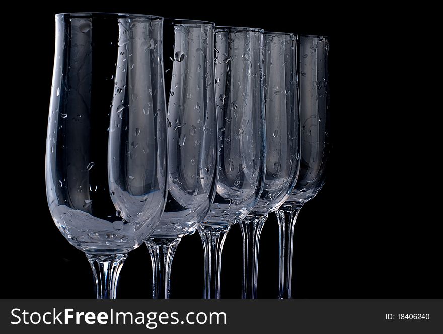 Five glasses with drops of water isolated on black background. All image in focus