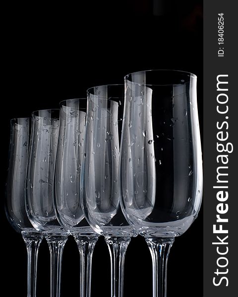 Five glasses with drops of water isolated on black background. All image in focus.