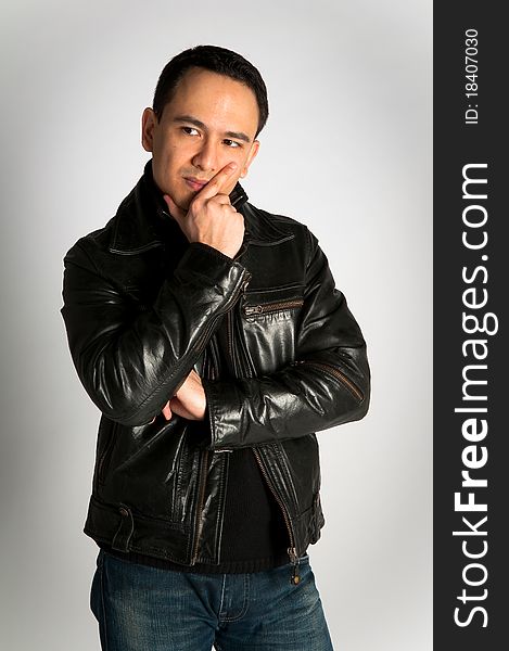 Tough attractive man in thoughtful pose in black leather jacket on white background. Tough attractive man in thoughtful pose in black leather jacket on white background