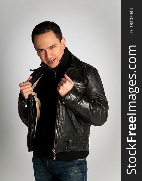 Tough attractive man with look in black leather jacket on white background isolated. Tough attractive man with look in black leather jacket on white background isolated