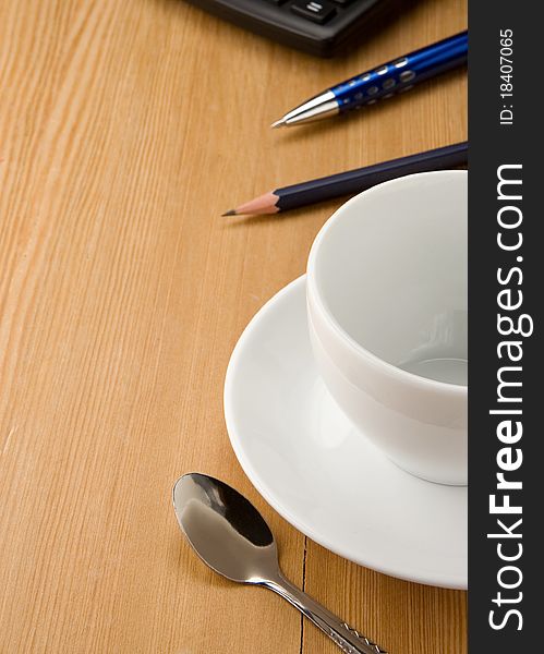 Pen, calculator and cup of coffee on wooden table