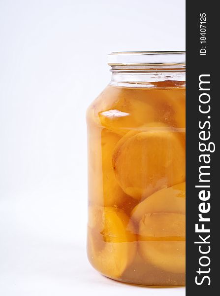 Glass jar with peach isolated on white