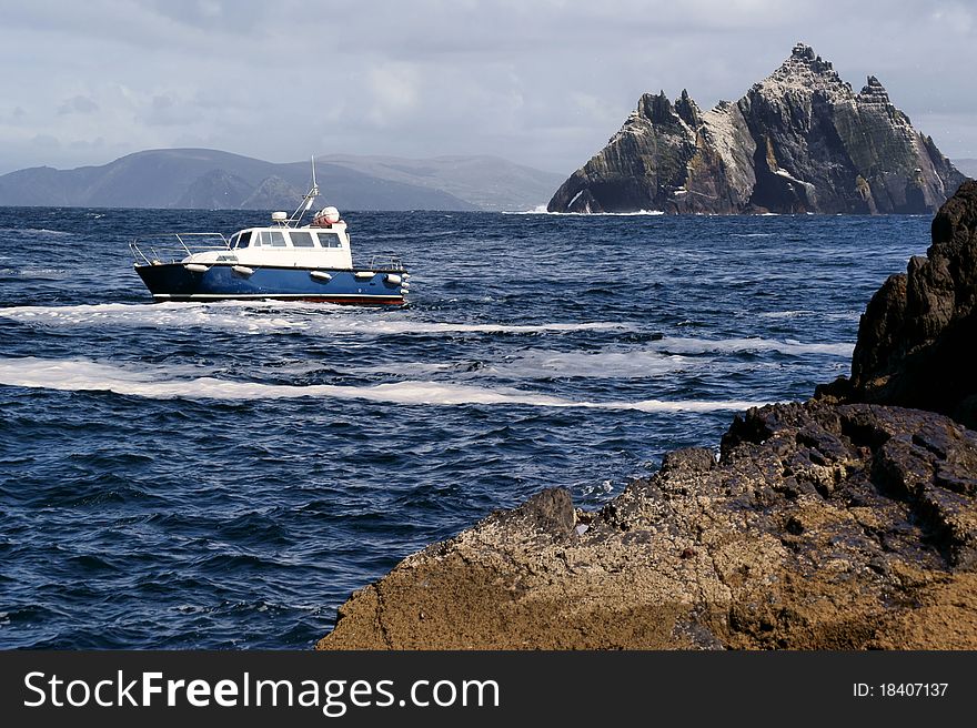 A small boat in choppy sea water amongst the rocks at the Skellig Islands, County Kerry, Ireland. A small boat in choppy sea water amongst the rocks at the Skellig Islands, County Kerry, Ireland