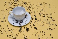 Tea Cup With Tea Leaves On A Yellow Table Stock Photography