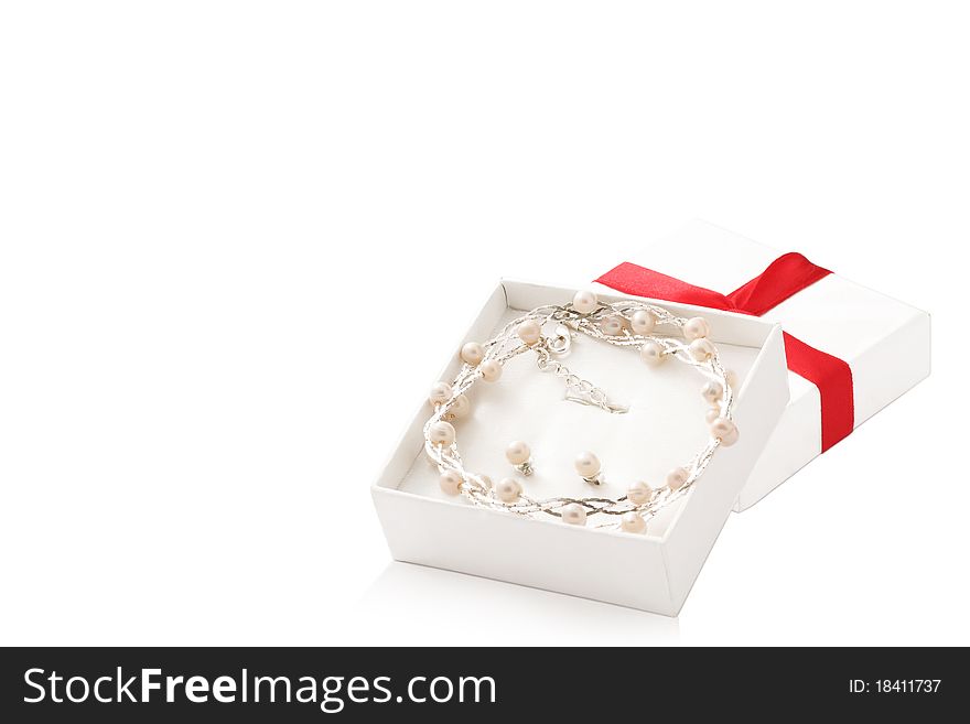 Open white box with pearl necklaces and earrings inside isolated on white background. Open white box with pearl necklaces and earrings inside isolated on white background