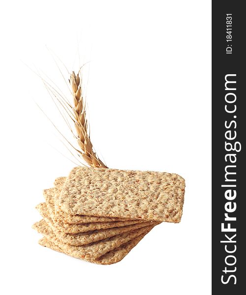 Stack of slices crispbread with spikelet wheat isolated on white