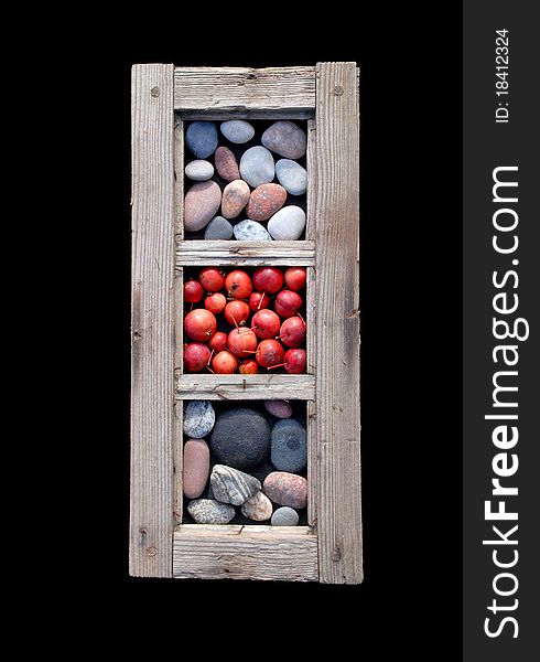 An old window frame with sea stones and little red apples in it. An old window frame with sea stones and little red apples in it.