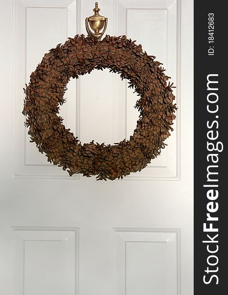 Brown wreath decorating white door of house for autumn. Brown wreath decorating white door of house for autumn