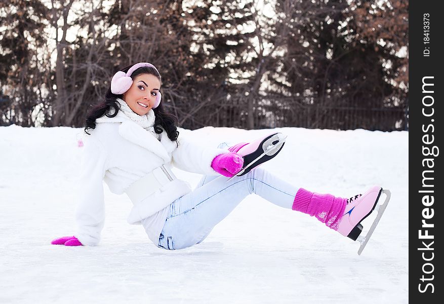 Beautiful young brunette woman ice skating outdoor