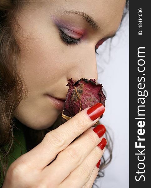 Beautiful girl smelling a rose remembering good times. Beautiful girl smelling a rose remembering good times.