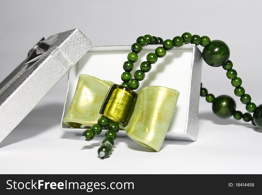 A green wooden, unique, handmade necklace as a gift in a silver box