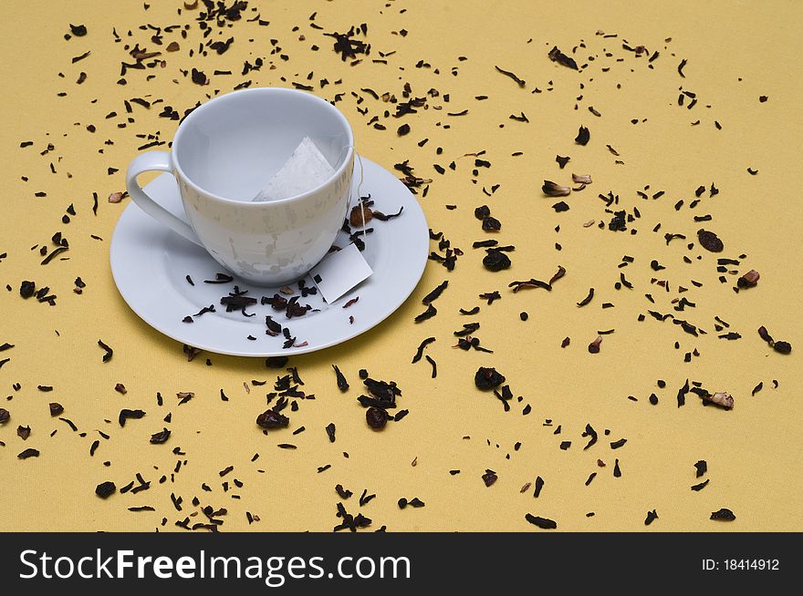 Some tea leaves with a tea cup. Some tea leaves with a tea cup