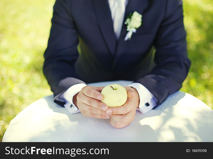 Groom with an apple in the garden