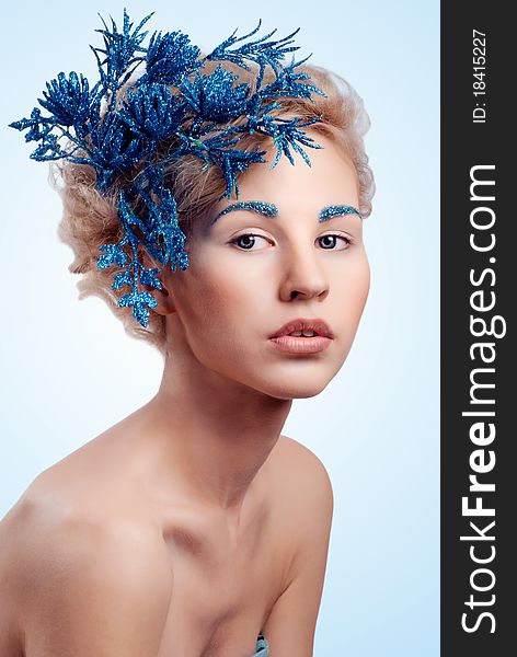 Beautiful winter girl with a blue flower in her hair