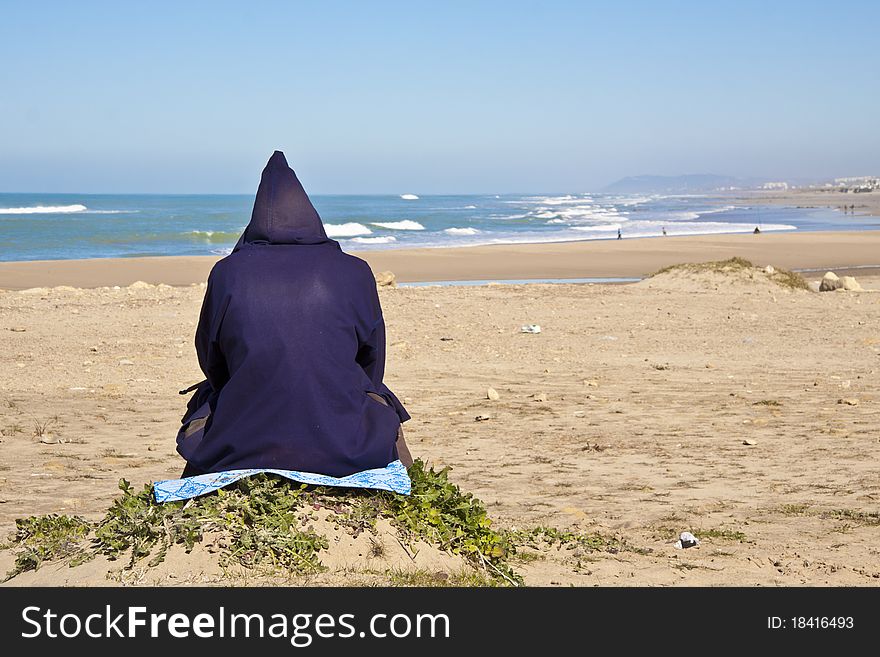 Traditionaly dressed moroccan man relaxing at the atlantic beach. Traditionaly dressed moroccan man relaxing at the atlantic beach