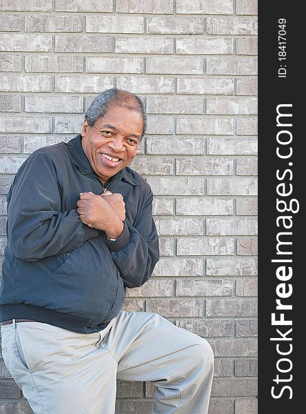 Expressions of an african american male standing against a wall outdoors. Expressions of an african american male standing against a wall outdoors.