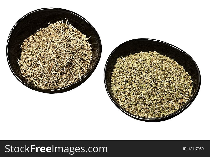 Rosemary and marjoram spices in black round bowls isolated on white background. Rosemary and marjoram spices in black round bowls isolated on white background.