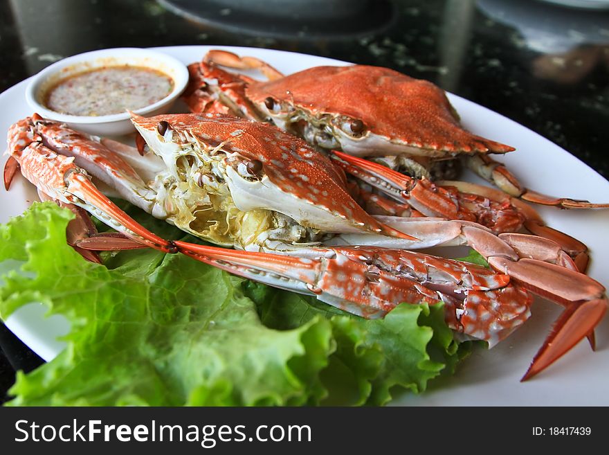 Two crabs in a dish with white sauce. Two crabs in a dish with white sauce.