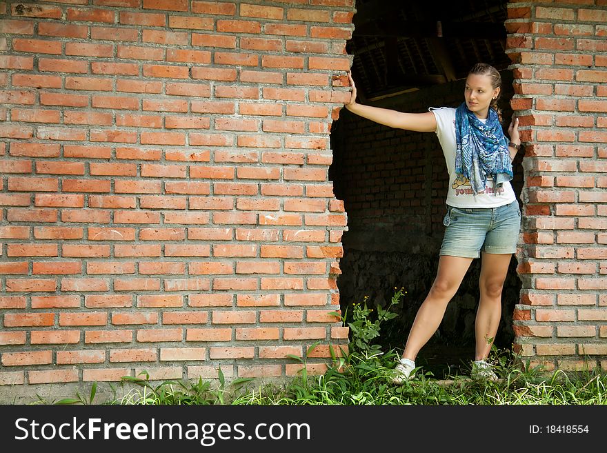 Woman Standing In The Doorway Of Brick Wall