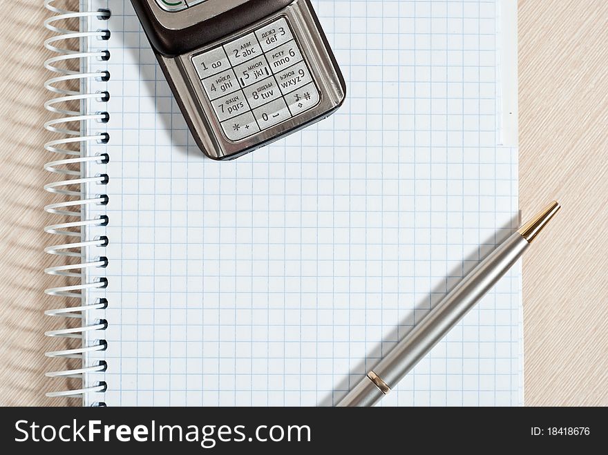 Mobile phone, notepad and pen on wood desk. Mobile phone, notepad and pen on wood desk