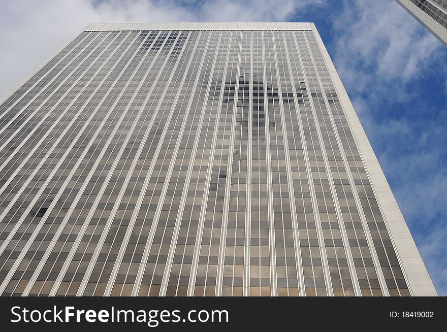 Modern office building with cloudy blue sky behind it. Multi floor building. Modern office building with cloudy blue sky behind it. Multi floor building