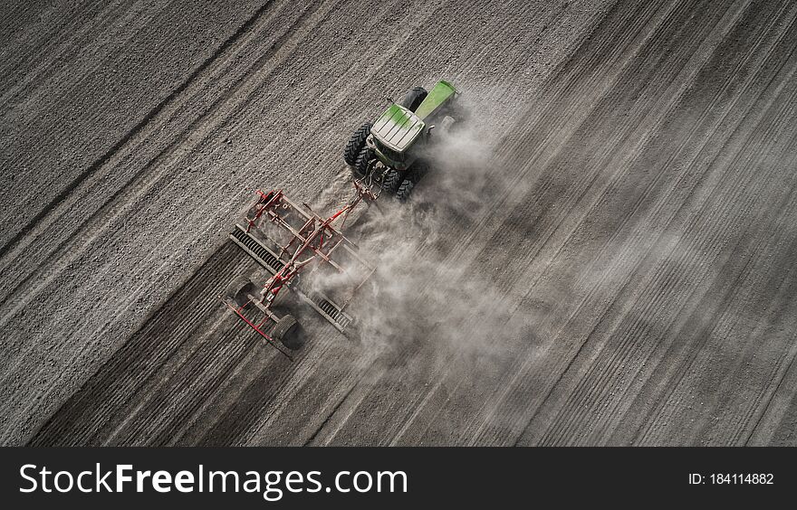 Farmers Cultivating. Tractor Makes Vertical Tillage. Aerial View